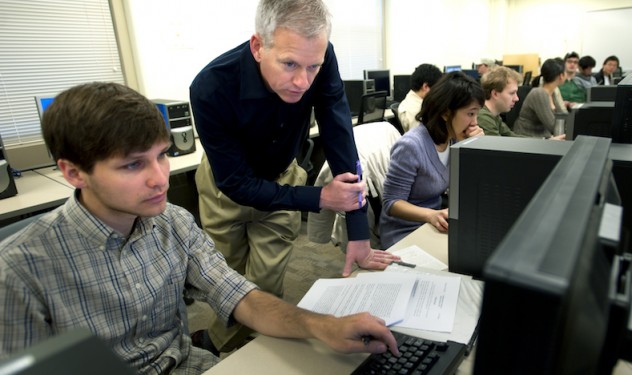 Instructor assisting a student in a computer lab.