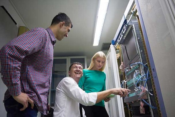 two men and a woman in a server room
